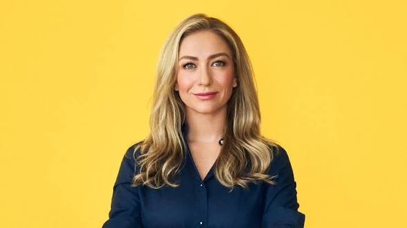 Portrait of Bumble founder Whitney Wolfe Herd against a bright yellow backdrop.
