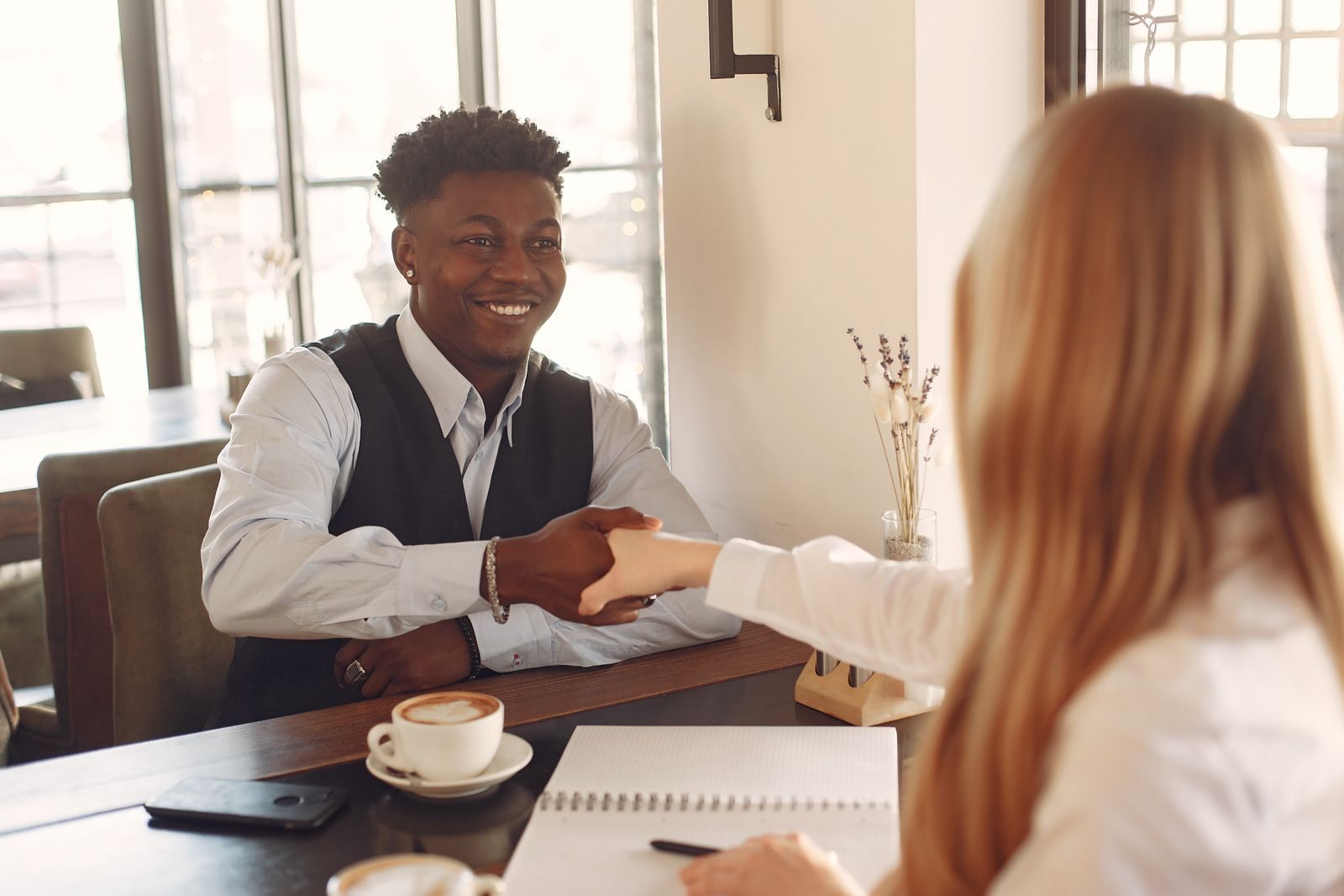 Professionals sit across a table reviewing printed documents during an interview.