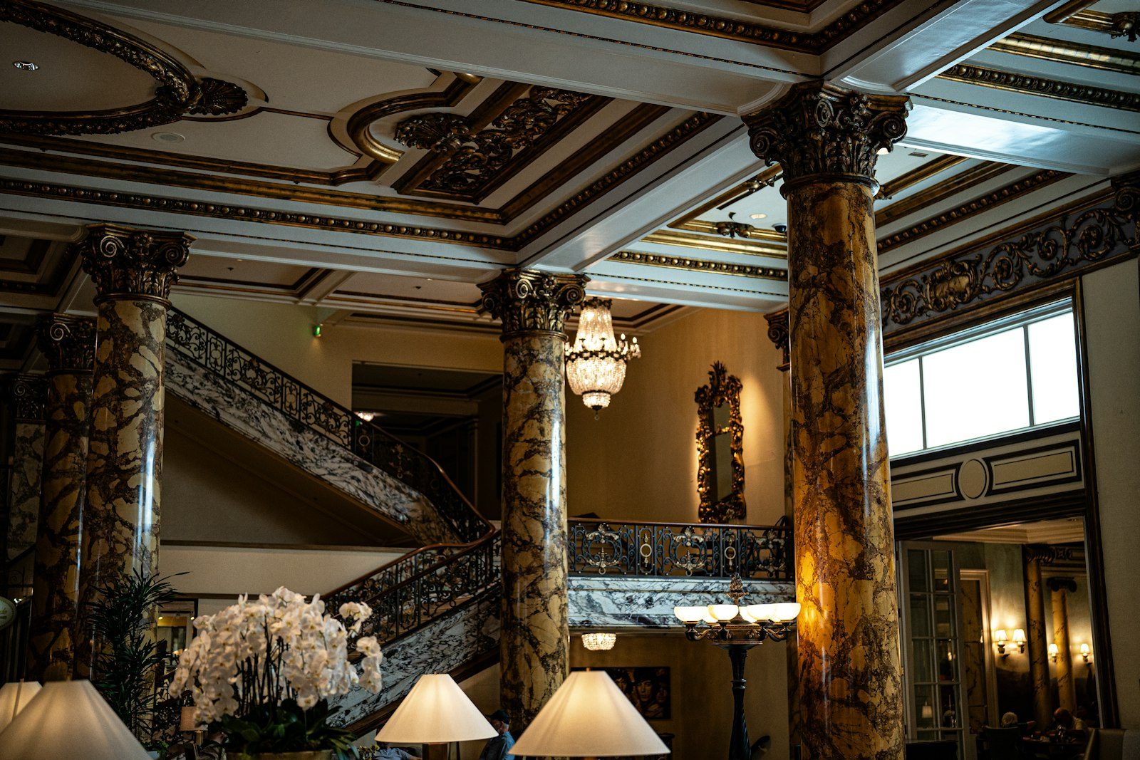 A luxury hotel lobby at dusk with warm lamps, fresh flowers, and a concierge desk.