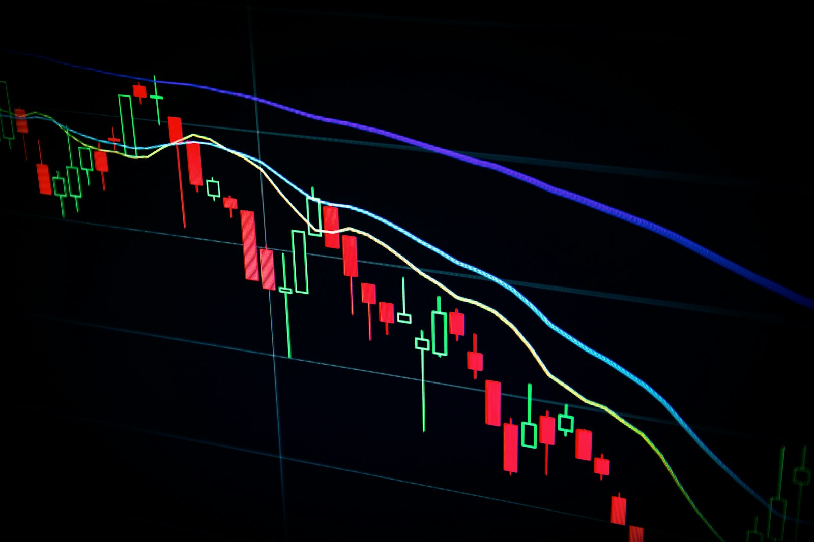 A stock market candlestick chart glowing on a dark screen.